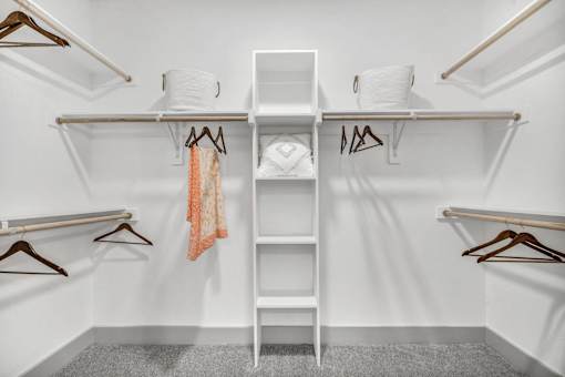 A white closet with a shelf and hangers.