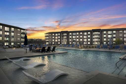 A modern pool area with a large rectangular pool and a smaller wavy pool next to it.