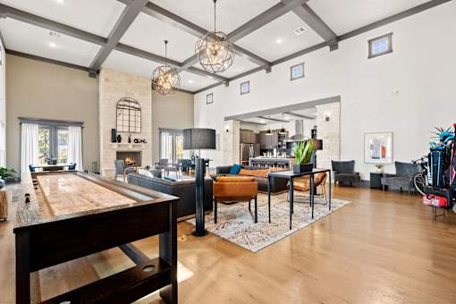 A well-lit, spacious living room with a pool table and a variety of seating options.