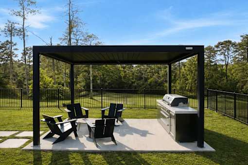 A black metal and concrete patio with a table and chairs.