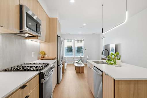 A modern kitchen with wooden cabinets and stainless steel appliances.