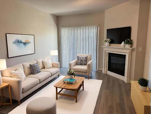 A living room with a white couch, a coffee table, and a fireplace.