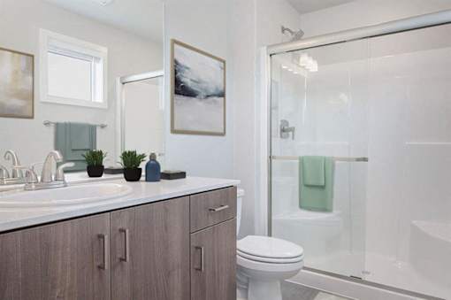 A bathroom with a toilet, sink, and shower.