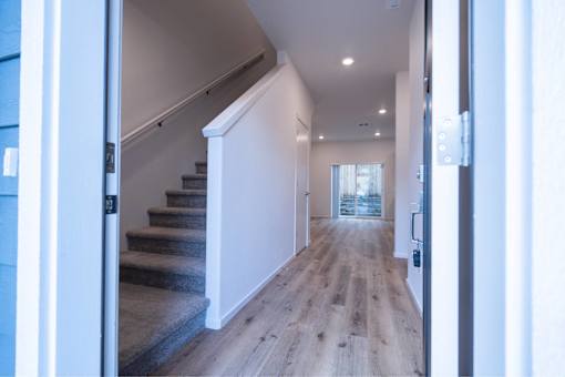 A hallway with a staircase leading to the second floor.