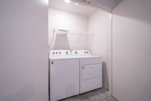 A white washing machine and dryer in a small laundry room.