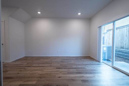 A room with wooden flooring and white walls.