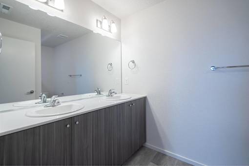 A bathroom with a white counter and a mirror above it.