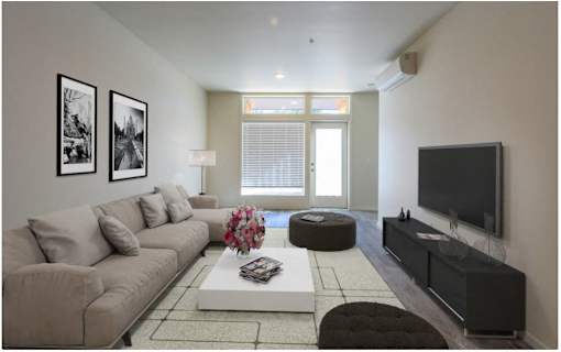 A living room with a grey couch, a white coffee table, and a flat screen TV.