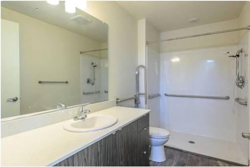 A bathroom with a white sink and a white toilet.