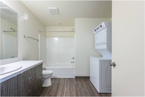 A white bathroom with a toilet, sink, and shower.