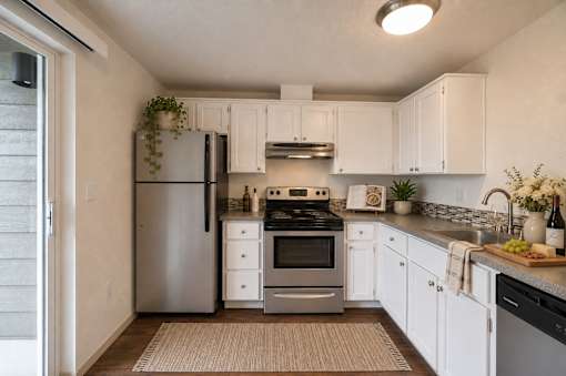 A kitchen with white cabinets and a stainless steel refrigerator.