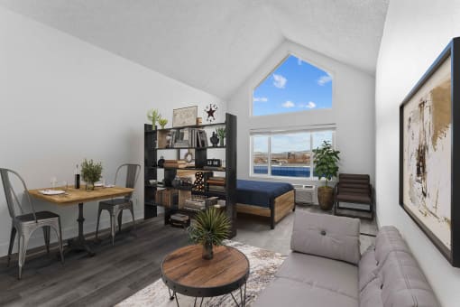an open living room with a couch and a desk and a window