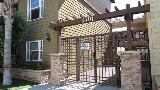 A brown gate with a sign that says "Private Property" in front of a house.