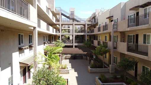 A courtyard surrounded by apartment buildings with a staircase in the middle.