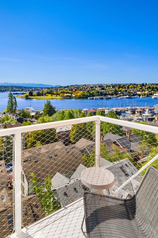 a balcony with two chairs and a table overlooking a body of water at Liza Apartments, Seattle, Washington, 98102