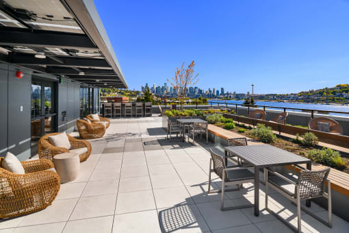 a patio with tables and chairs and a view of the city at Liza Apartments, Seattle