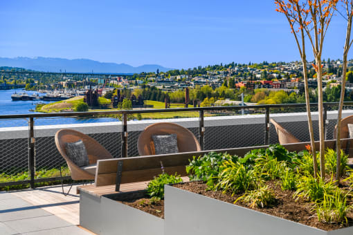 a balcony with chairs and a bench overlooking a river and a city at Liza Apartments, Seattle, Washington, 98102