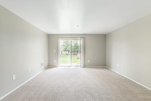 an empty room with a door leading to a yard