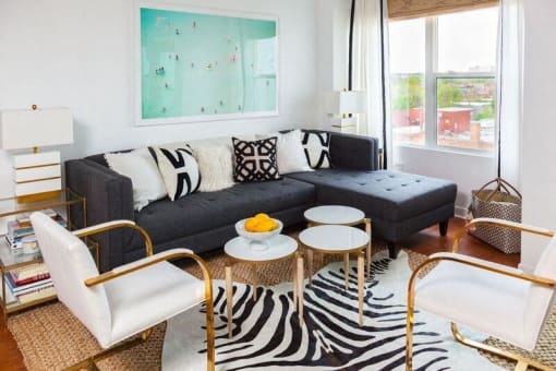 a living room with a black couch and tables