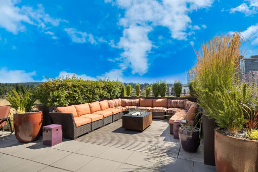 Lux Apartments rooftop patio with couches and tables and potted plants
