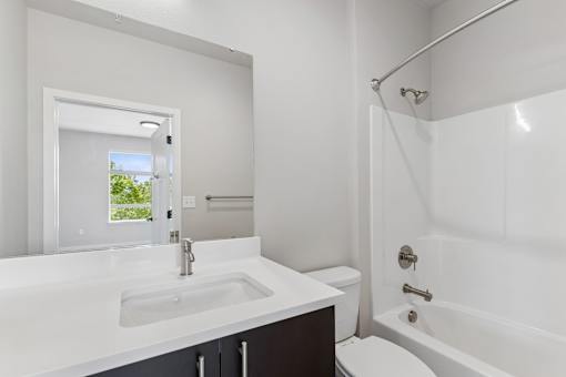 A white bathroom with a sink, toilet, and bathtub.