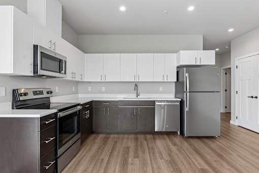A modern kitchen with stainless steel appliances and wooden floors.