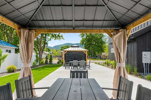 A patio with a table and chairs under a canopy.