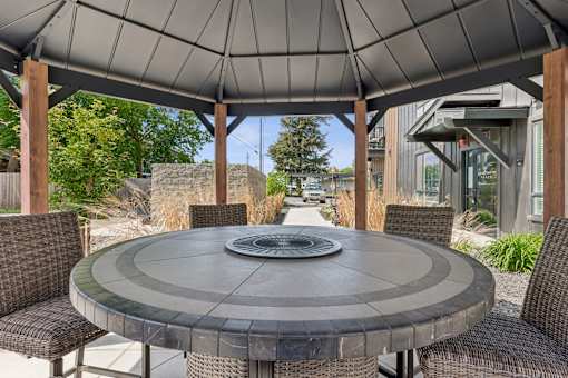 A patio with a table and chairs under a grey canopy.