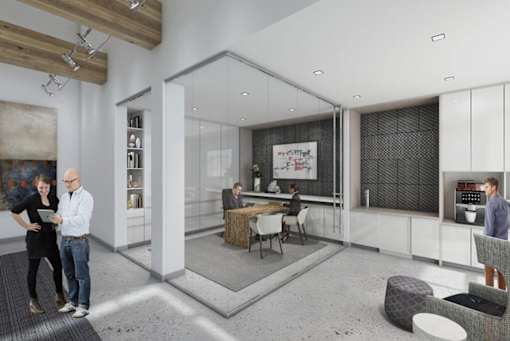 A modern kitchen with people standing and sitting around a table.