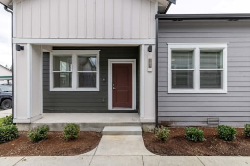 the front of a home with a brown door and a sidewalk