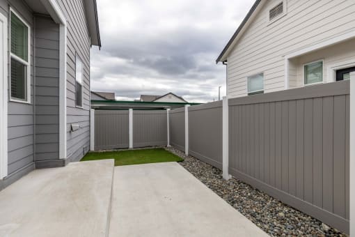 the yard of a home with a white fence and grass