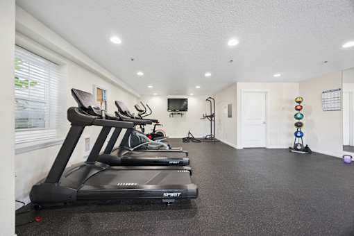 Community fitness center with new equipment like treadmills and weights at Springwater Crossing apartments in Gresham, Oregon 97030