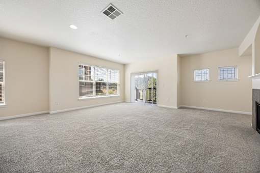 Spacious living room with large windows and sliding glass door to patio or balcony at Springwater Crossing apartments in Gresham, Oregon 97030