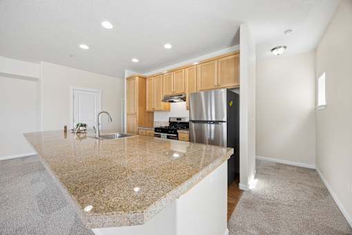 A kitchen with granite countertops and wooden cabinets at Springwater Crossing in Gresham, Oregon