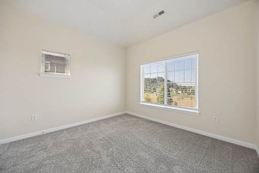 Bedroom with large window and light walls at Springwater Crossing apartments in Gresham, Oregon 97030