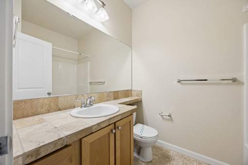 Bathroom with wooden cabinets and large mirror at Springwater Crossing apartments in Gresham, Oregon 97030