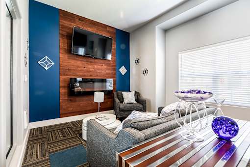 A modern living room with a grey couch and a wooden wall.