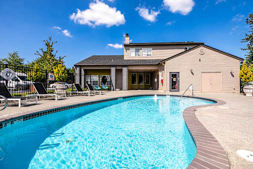 A swimming pool in front of a house.