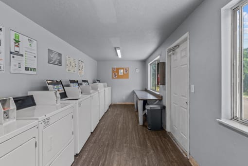 a laundry room with washes and dryers and a window