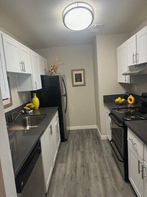 a kitchen with white cabinets and stainless steel appliances