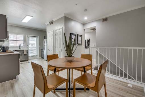 A dining room with a round table and chairs.