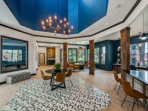 A modern dining room with a large table and chairs.
