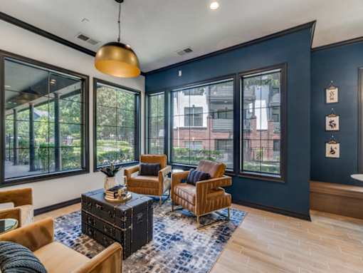 A living room with a large window and a view of a building outside.