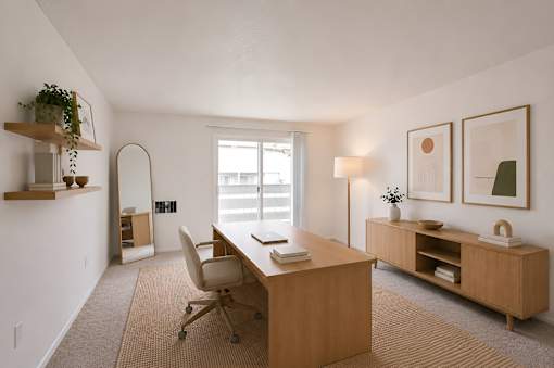 A room with a desk, chair, and shelves with plants.