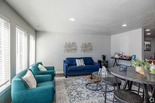 A living room with a blue couch and a grey table.