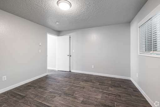 Living space with dark, wood-style floors and grey walls at The Groove apartments in the Hazel Dell 98665 neighborhood in Vancouver, Washington.