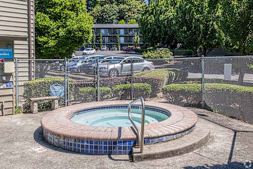 A small round pool with a metal ladder sits in the middle of a concrete patio.
