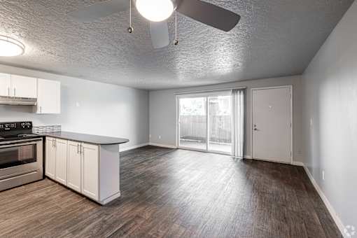 Open floorplan with kitchen island looking out into living room and patio at The Groove apartments in the Hazel Dell 98665 neighborhood in Vancouver, Washington.