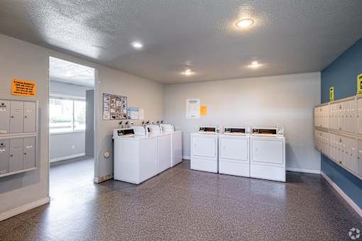 Community laundry room with white walls at The Groove apartments in the Hazel Dell 98665 neighborhood in Vancouver, Washington.