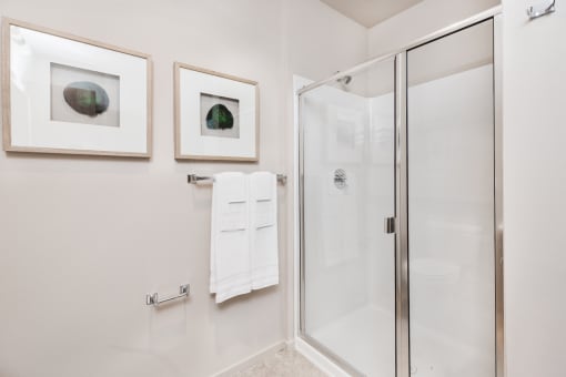 bathroom with a glass shower and two pictures on the wall at The Hayes on Stone Way, Washington, 98103